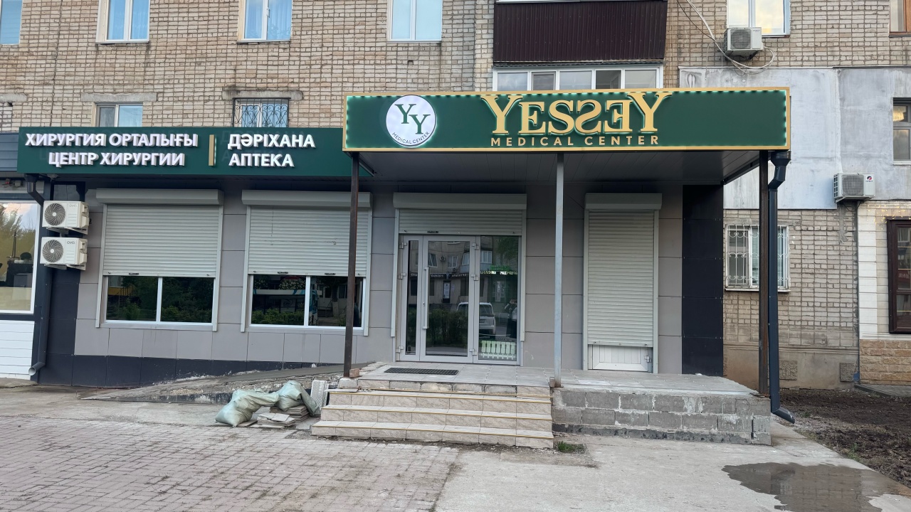 Вход в Yessey с зелёной вывеской, слева вывеска аптеки